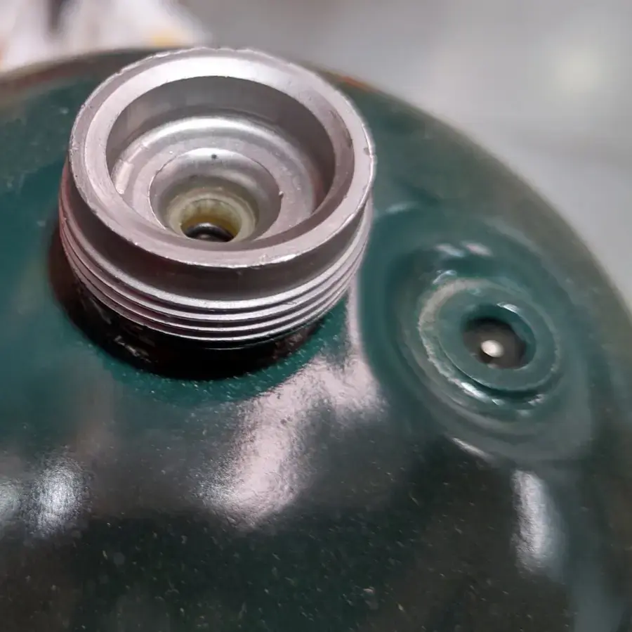 Close photograph of the threaded valve on a one-pound disposable propane cylinder